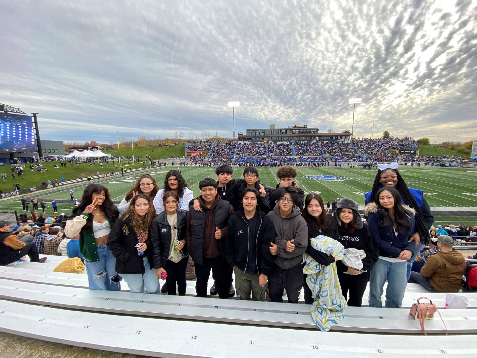 A group of students standing in the GVSU football staduim stands